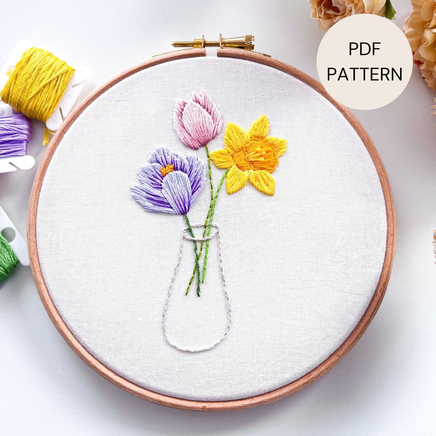Spring Flowers Hand Embroidery Pattern featuring a Yellow Daffodil, Purple Crocus and Pink Tulip in a clear vase.