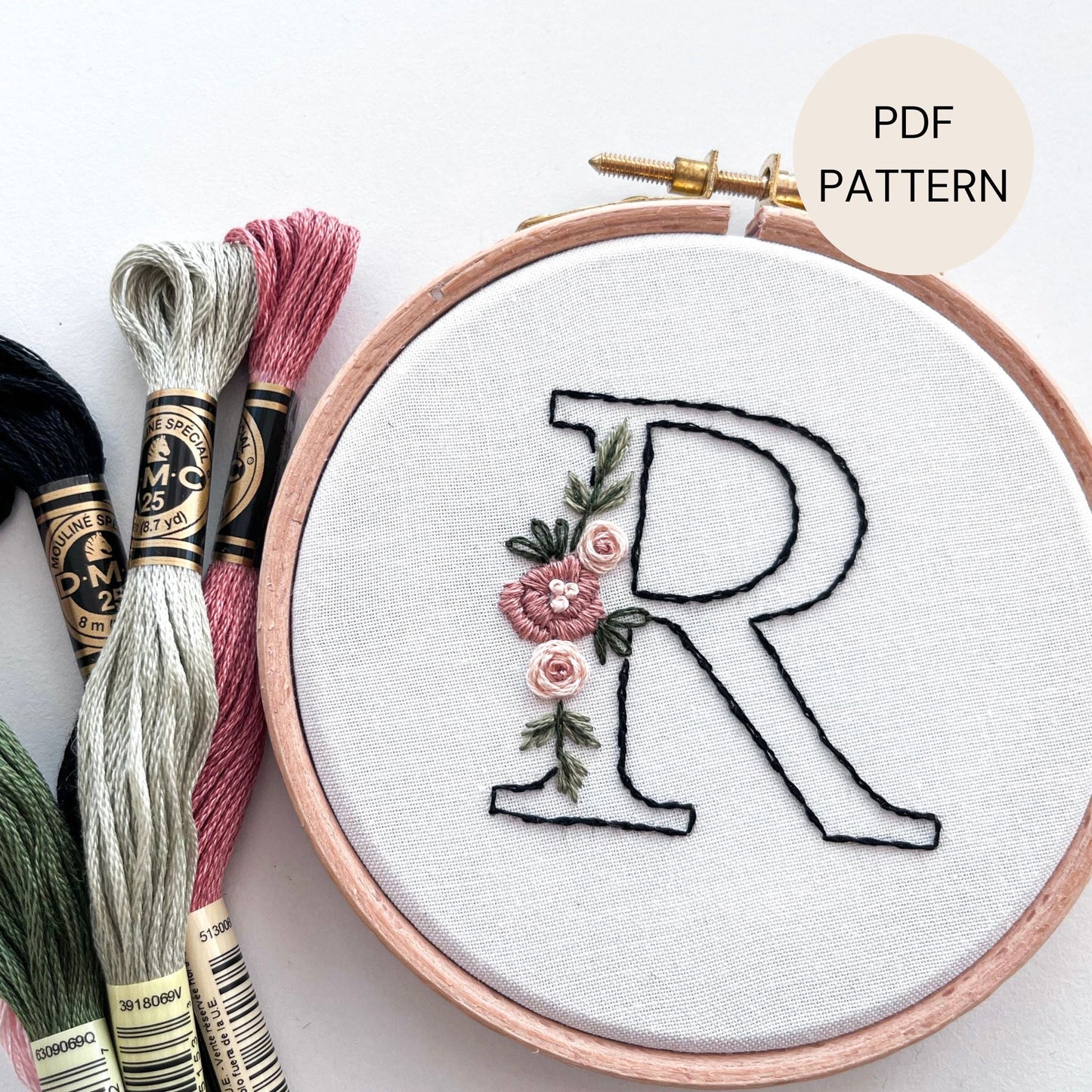 Letter needlecraft pattern for beginners pictured alongside embroidery thread