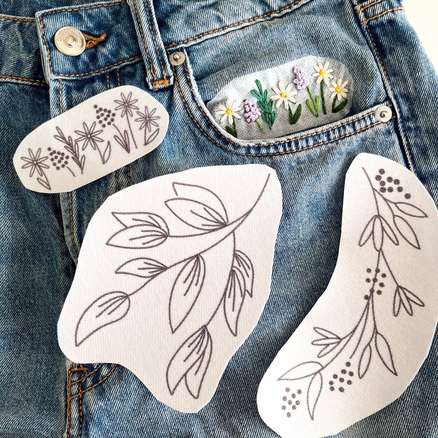 Three floral patterns printed on water soluble fabric stabiliser for embroidery.