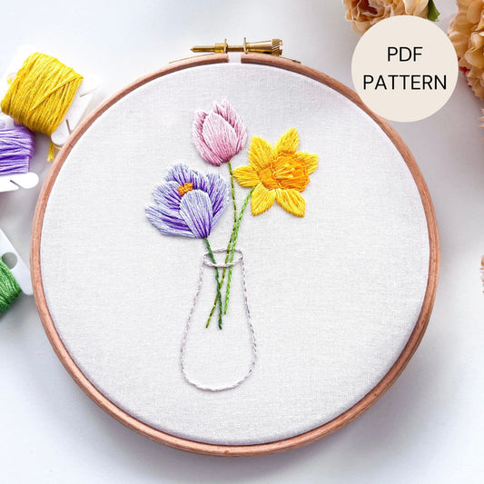 Spring Flowers Hand Embroidery Pattern featuring a Yellow Daffodil, Purple Crocus and Pink Tulip in a clear vase.