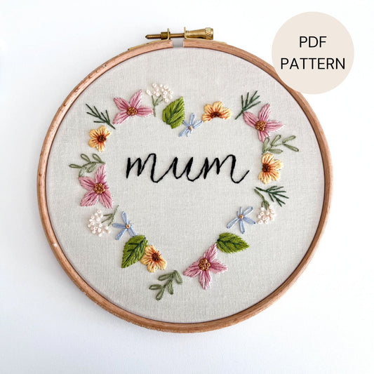 Hand embroidered flowers stitched in a heart shape with the word mum stitched in the centre.