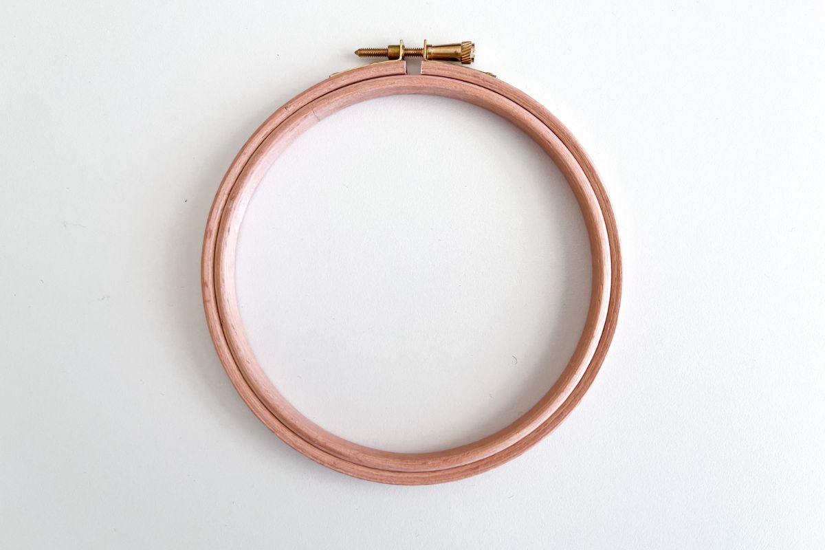 wooden embroidery hoop with two hoops and screw at the top for holding fabric for hand sewing.